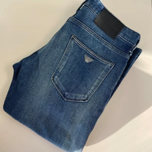 Emporio Armani Jeans - Säljer ett par stilrena Armani jeans i storlek W29. Mörkblå tvätt med klassisk design som funkar till det mesta. 	•	Storlek: W29 	•	Skick: Väldigt bra, sparsamt använda 	•	Mjukt och bekvämt material med lätt stretch 	•	Diskret Armani-logga på bakfickan