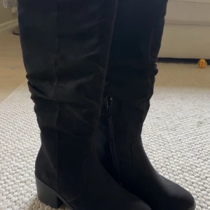 Svarta höga stövlar med låg klack - Säljer ett par svarta höga stövlar, sprillans nya då de va försmå för mig🌼 Nypris ligger på ca 900kr