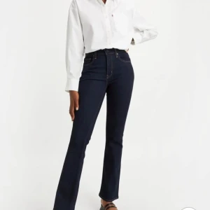 Mörkblå bootcut jeans från Levi's - Säljer ett par mörkblå bootcut jeans från Levi's med klassisk femficksdesign och hög midja. Jeansen har en snygg passform som sitter tight upptill och släpper ut vid bensluten. Perfekta till både sneakers och boots. Använd max 3-5 gånger.                                                                 Storlek 26, passar mig som är 165cm Modell: 725 high rise bootcut blue wav