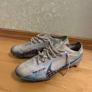 Nike Air Zoom Mercurial Vapor 15 Elite FG Blast - Original skor, NIKE AIR ZOOM MERCURIAL VAPOR 15 ELITE FG BLAST. Skorna använda fåtal gånger, mycket bra skick. Dessa skor är till för användning på naturgräs. Nypris 3049kr.  Storlek 45,5 (US 11.5 / UK 10.5 / EUR 45.5).  Fler bilder kan skickas i meddelande. Priset kan diskuteras vid intresse!