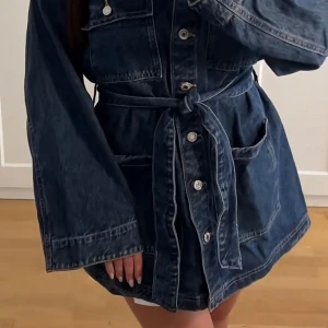 Jeans jacka med knytband - Säljer denna super snygga slutsålda jeans jackan köpt på H&M för två veckor sen. Den är i en mörkblå jeans tvätt färg. Den har endast använts en gång och är därför i helt nytt skick. Den är i storlek S och är lite oversized som på bilden.🤍