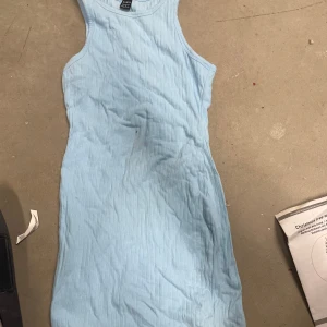 Ljusblå ribbad klänning från SHEIN - Säljer en ljusblå ribbad klänning från SHEIN i storlek XS. Klänningen är ärmlös och har en kroppsnära passform med rund halsringning. Perfekt för varma dagar eller sommarens alla tillfällen.