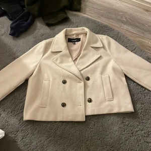 Beige kappa från Vero Moda - Säljer en beige kappa från Vero Moda. Perfekt vår/höst jacka