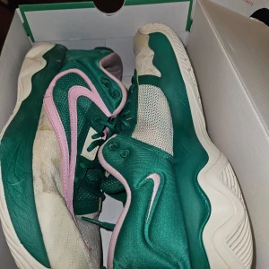 Nike Giannis Immortality 3 grön och vit  - Säljer ett par Nike Giannis Immortality 3 sneakers i färgen malachite med gröna och vita paneler samt rosa swoosh. Skorna har snörning, rund tå och platt sula. Perfekta för dig som gillar basket och vill sticka ut med färgglada skor.