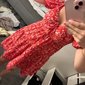 Röd blommig kortklänning med puffärm - fin röd klänning från gina tricot som tyvärr aldrig kom till användning, går att ha den som vanligt men också off shoulder. (nypris 500)