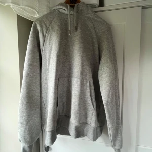 Grå hoodie från ICIW med huva - Säljer en stilren ljusgrå hoodie från ICANIWILL med broderad logga på bröstet. Tröjan har huva med snörning och en magficka, säljer då den är för stor för mig💗