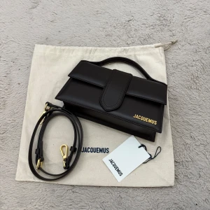Jacquemus le grand bambino bag (brun) - Säljer en stilren brun handväska från Jacquemus med guldiga detaljer och avtagbar axelrem. Väskan är helt ny, tags, dustbag & avtagbar strap medföljer. Perfekt för dig som gillar  lyxig design.