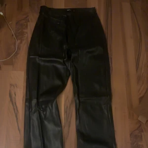 Svarta skinnbyxor från BikBok - Snygga svarta skinnbyxor från BikBok. Sitter som mid men kan vikas ner snyggt till low waist. endast använda 1 gång så dom är helt som nya