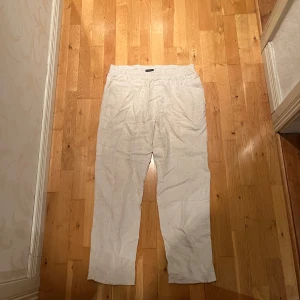 Beiga linnebyxor från H&M Regular Fit - Säljer ett par oanvända beiga linnebyxor från H&M i regular fit. Byxorna har resår i midjan och är tillverkade i ett luftigt linnematerial, perfekta för varmare dagar. Avslappnad passform och stilren look som funkar till många outfits.