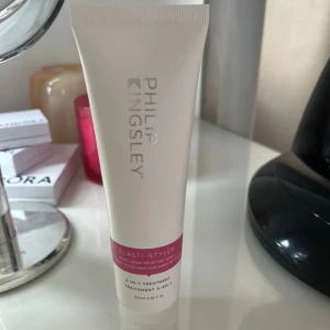 Philip Kingsley Elasti-Styler 100ml - Elasti-Styler från Philip Kingsley är en 5-i-1 behandling för håret i en vit tub med rosa detalj. Produkten är framtagen för att ge vård, skydd och styling till alla hårtyper. Tuben rymmer 100 ml och har en stilren design.