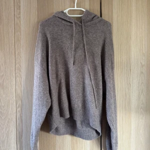Beige stickad hoodie från Lindex - Mysig beige stickad hoodie från Lindex i storlek S. Tröjan har huva med snörning, långa ärmar och ribbade muddar. Perfekt för lager-på-lager och chill dagar. Enkel och stilren design som passar till det mesta.