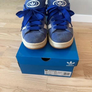 Adidas Campus 00s blå sneakers - Snygga adidas campus 00s blå, storlek 40 2/3 och säljer dem på grund av att dem är för små. Har aldrig använt de andra två sko snörena
