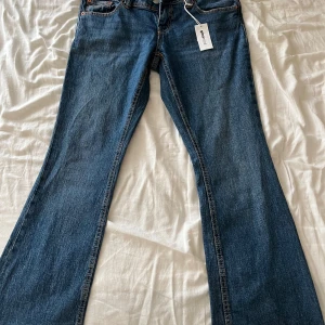 Blå bootcut jeans från Perfect Jeans - Snygga blå bootcut jeans från Perfect Jeans i storlek 40. Klassisk femficksmodell med detaljer på bakfickorna och kontrastsömmar. Jeansen har normal passform och är tillverkade i slitstarkt denimtyg.