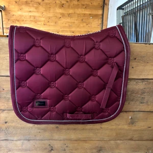 Bordeaux dressyrcharbrak ES - Dressyrschabrak från Equstrain Stockholm i färgen Bordeaux och storlek cob❤️Sparsamt användt och har inga större defekter. Färgen blir lite konstig i kameran (bild 3 från hemsidan ger mer rättvis färg) Nypris 899kr! Pris går att diskutera