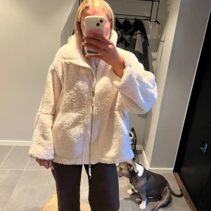 Vit teddyjacka med dragkedja - Mysig och oversized vit teddyjacka med hög krage och hel dragkedja framtill. Perfekt till hösten och vintern. För referens är jag 180 cm lång. 
