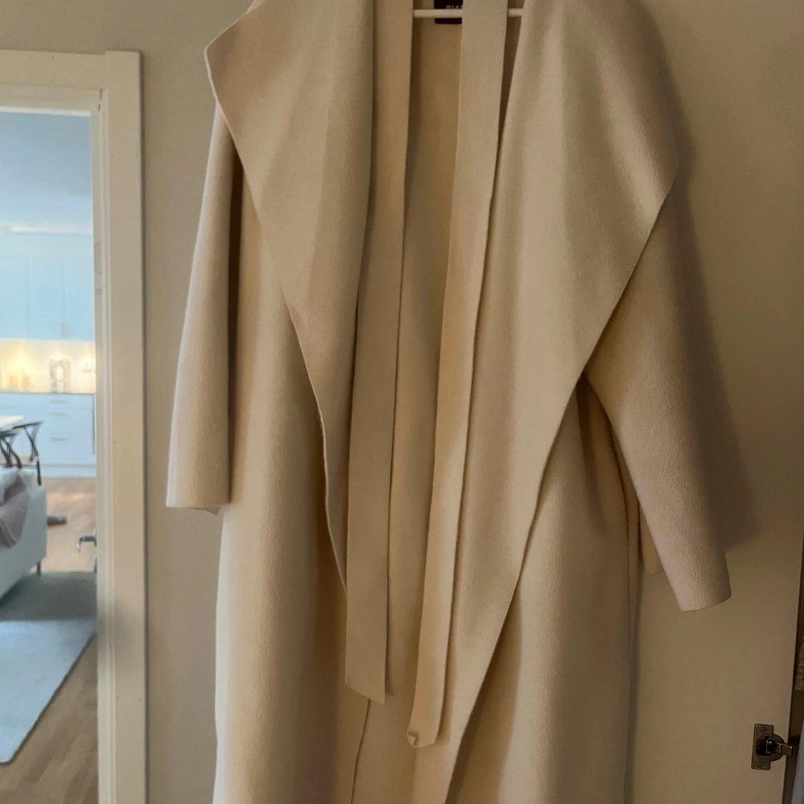 Beige kappa med bälte och bred krage - 1