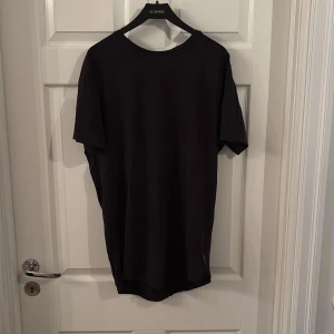 Svart basic t-shirt i bomull - Enkel svart t-shirt med rund hals och korta ärmar. Modellen är rak och passar perfekt till jeans eller shorts. Tillverkad i mjuk bomull för en skön känsla hela dagen.