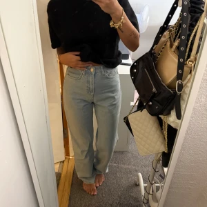 Ljusblå raka jeans med hög midja - Säljer ett par ljusblå jeans med rak passform och hög midja. Jeansen har klassisk femficksdesign, knapp och dragkedja framtill. Materialet är jeans och de har en chill, loose vibe som passar perfekt till en enkel t-shirt eller hoodie.