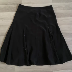 Svart Vintage utsvängd kjol med paljettdetaljer - Vintage  kjol med utsvängd form och diskreta paljettdetaljer längs sömmarna. 