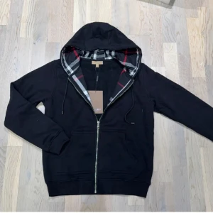 Svart burberry hoodie - Säljer denna riktigt feta svarta burberry zip Hoodien i bra skick. Tags kvar! Står storlek S men e liten i storleken så kan passa XS också! Pris kan diskuteras vid snabb affär!