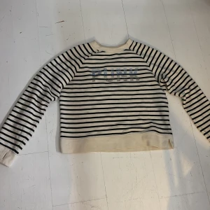 Randig tröja från Zadig & Voltaire - Snygg randig tröja från Zadig & Voltaire i vitt och svart med glittrande stenar i blått och silver som bildar texten 'PUNK' på bröstet. Tröjan är lång ärmad. Bra skick använt typ 2 gånger 