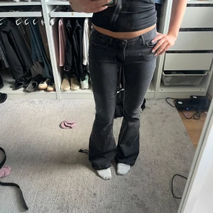 Svarta bootcut jeans låg midja - Säljer ett par svarta jeans med snygg bootcut och låg midja. Jeansen har klassisk femficksdesign och är tillverkade i ett stretchigt denimtyg som sitter skönt. Perfekta om du gillar en retro vibe och vill ha ett par jeans som framhäver benen. Har sytt ner dom lite, lite upptrampade 