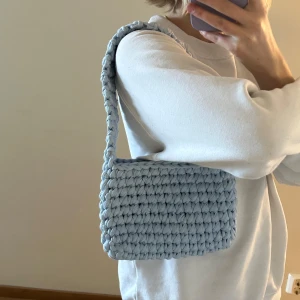 Virkad väska i ljusblå - Hemmavirkad handväska, gjord i t-shirtgarn som är gjort av textilindustrins tygöverskott.   Mått: ca 22cm bred, 15cm hög och 38cm hög (inklusive handtag)