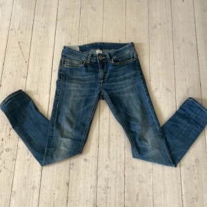Blå jeans från Dondup, storlek 27 - Snygga blå jeans från Dondup i klassisk tvätt med slitningar och kontrastsömmar. Modellen har raka ben, fyra fickor och läderpatch med logga bak. Jeansen är i bomull och har en normal passform som sitter skönt hela dagen. Jeansen är i väldigt bra skick. W27 L 30 Säljs för 550, kontakta om frågor.