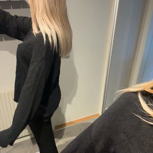 Svart polotröja - Säljer en stilren svart polotröja med långa ärmar. Perfekt för en minimalistisk look och passar bra till både jeans och kjol. Tröjan har en lös passform som ger en avslappnad känsla.