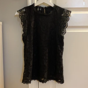 Svart spetsblus från Pieces💓 - Superfin svart spetsblus från Pieces. Blusen har vackra spetsdetaljer och korta ärmar. Säljer pågrund av att den ej har kommit till användning (använd 3 gånger) Den är i storlek S💓💓komtakta vid fler frågor💞