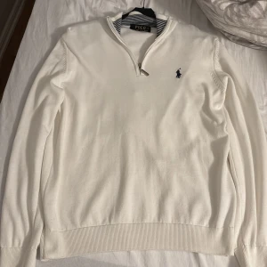 Vit tröja med dragkedja från Ralph Lauren - Säljer en stilren vit tröja från Ralph Lauren med dragkedja och broderad logga på bröstet. Tröjan har långa ärmar. Helt ny skick det vill säga inga defekter. Pris kan diskuteras. Storlek L men sitter som M