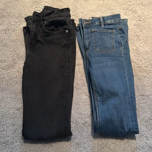 Svarta och blå bootcut jeans - Två par bootcut jeans, ett par i svart och ett i blå denim. De svarta jeansen har en klassisk design med fickor och knappdetaljer. De blå jeansen har en ljusare tvätt med framträdande sömmar och bakfickor. Perfekta för en avslappnad stil.