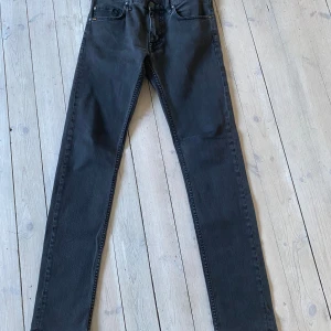 Svarta jeans från Tiger of Sweden - Snygga svarta jeans från Tiger of Sweden i modellen Sharp. De har en stilren design med en klassisk femficksmodell och knappgylf. Perfekta för en stilren look. Storleken är 32/34 och skicket väldigt bra. 