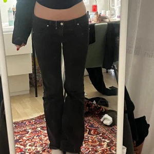 Lågmidjade Svarta bootcut jeans - Snygga svarta bootcut jeans med låg midja. Storlek typ 40 tror jag men jag brukar normalt ha 36/S i byxor så de är väääldigt små i storleken. Fint skick, inga defekter. Jag är 176 så de är även långa i benen!