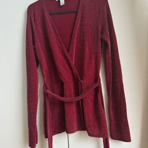 Omlott - Glittrig omlott med knytband från Nelly