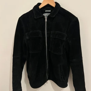 Svart mocka jacka från human scales strl.M - Snygg svart mockajacka från humanscales, som passar perfekt nu när de börjar bli säsong för lite tunnare jackor. Jackan är storlek S och den sitter bra på mig förutom att den är lite lång i armarna (Jag är ca 174cm)