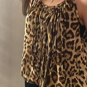Leopardmönstrad ärmlös topp - Säljer en snygg ärmlös topp med leopardmönster och plisserade detaljer framtill. Passar till många olika stilar.