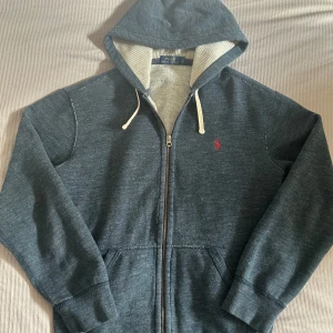 Mörkblå hoodie från Ralph Lauren - Säljer en snygg mörkblå hoodie från Ralph Lauren med dragkedja och huva. Nypris 1200kr+, vi säljer den för 549. Som vanligt, priset är inte hugget i sten!🤝🦾
