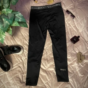 Svarta träningsleggings från Blacc - Snygga svarta träningsleggings från Blacc med elastisk midja och logotypdetaljer. Perfekta för träning eller en avslappnad dag. De är tillverkade i ett stretchigt material som ger en bekväm passform.