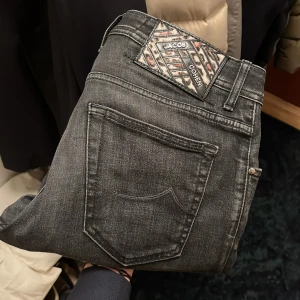 Jacob Cohen jeans  - Snygga grå jeans från Jacob Cohen med en stilren design. De har en klassisk femficksmodell och en knappgylf. Perfekta för en avslappnad men ändå stilfull look.