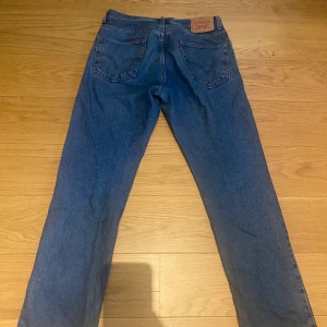 Vintage Levis 501 jeans - Klassiska blå Levis 501 jeans med rak passform. Vintage från 90tal, storlek 33W 32L Bra skick men har litet märke på ena sidan och sömmen öppen nertill so. Syns på bild 