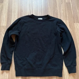 Svart sweatshirt från Acne Studios - Säljer en stilren svart sweatshirt från Acne Studios. Tröjan har en klassisk rund hals och långa ärmar, perfekt för en avslappnad look. Den är tillverkad i ett mjukt material som ger en skön känsla. Passar bra till både jeans och joggers.