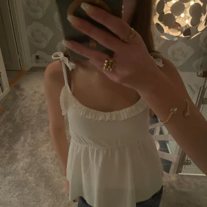 Vit volangtopp - Sötaste sommartoppen med knyt på axlarna🥹💕🌼säljer då jag jag redan hade en likadan när jag köpte, alltså helt ny och oanvänd, fast bortklippta lappar🌟🌼 bara att skriva för fler bilder😇💕