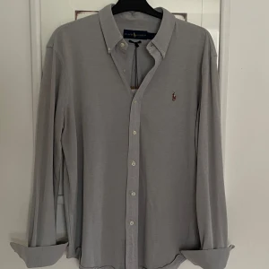 Grå Ralph Lauren skjorta - Snygg grå skjorta från Ralph Lauren med klassisk krage och broderad logga på bröstet. 