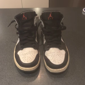 Nike Air Jordans i svart och vitt - Snygga Nike Air Jordans i svart och vitt med röda detaljer. Skorna har klassisk snörning och en ikonisk design med Nike-loggan på sidan. Köpte dem för 2300 kr och de är i väldigt bra skick. 
