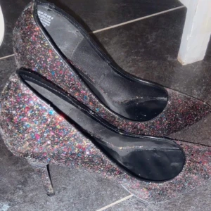 Glittriga pumps med spetsig tå - Snygga glittriga pumps med spetsig tå och hög klack. Perfekta för att lysa upp vilken outfit som helst. De har en elegant design som passar för festliga tillfällen.