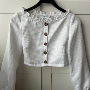 Vit blus från Misslisibells kollektion med NAKD - Topp från NAKD, Misslisibells kollektion strl 34. Aldrig använd har inga fläckar eller märken. Kan skicka fler bilder om önskas! 