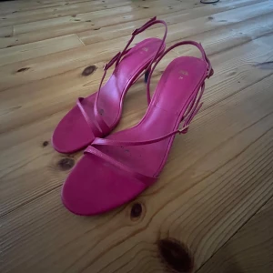 Rosa sandaler med klack - Snygga rosa sandaler med smala remmar och klack. Perfekta för en somrig look. De har en elegant design med justerbara spännen för bästa passform.