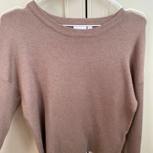 Finstickad tröja - Jätte fin stickad tröja med guldiga knappar i armen, färgen ser lite annorlunda ut på första bilden men den är ljus brun/beige