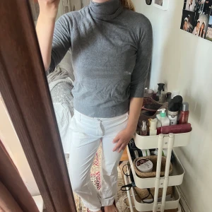 Grå polotröja från Zara - Snygg grå polotröja från Zara med ribbad krage och muddar. Tröjan har trekvartsärm och sitter normal mot kroppen. Perfekt att styla med jeans eller kostymbyxor för en clean look.